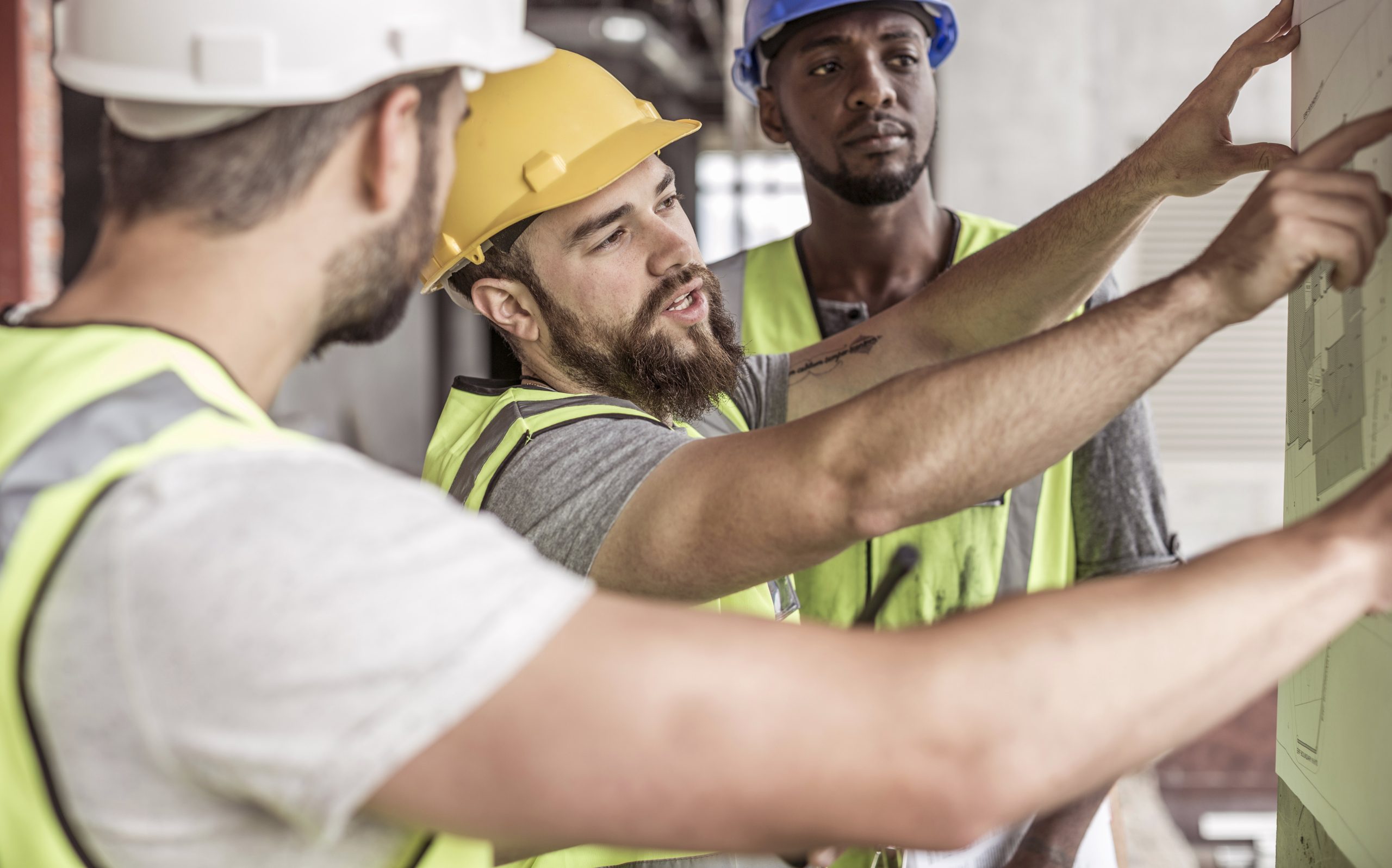 Construction workers discussing building plan in construction site
